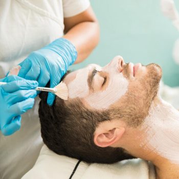 profile-view-young-man-getting-moisturizing-facial-treatment-health-spa